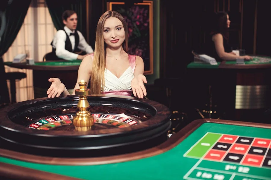 Tampilan ruang kasino live dengan meja permainan dan dealer